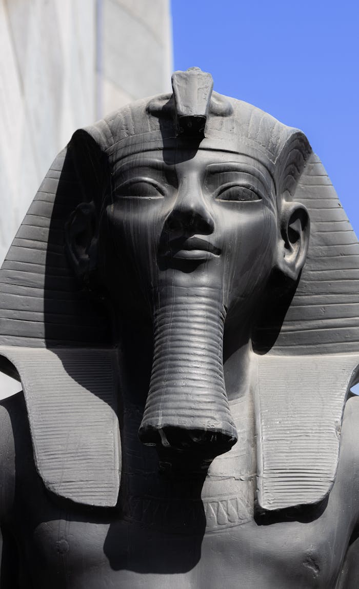 Close-up of an ancient Egyptian pharaoh statue against a clear sky in Dubai.